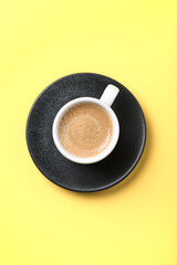 Cup of coffee on yellow  background. Top view. Copy space.