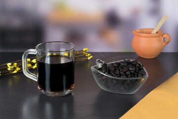 international coffee day, traditional colombian drink, close-up of glass of coffee and roasted coffee on the table in the kitchen