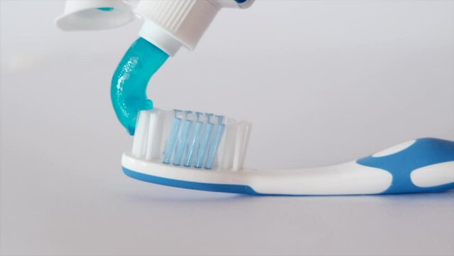 Toothpaste on toothbrush on white background