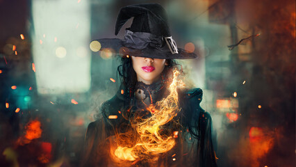 Halloween Witch . Beautiful young woman in witches hat conjuring, making witchcraft. Over spooky...