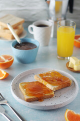 Sandwiches with marmalade, orange juice and coffee ready for breakfast	