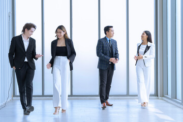 Four young men and women in Asian suits are meeting at a company Happy and excited about work. The concept is Finance, Marketing, Accounting.