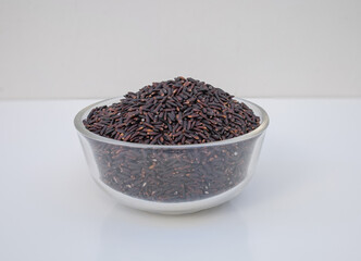 Uncooked dry rice in glass bowl isolated on white ,side view 