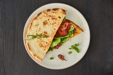 Pita bread filled with meat, vegetables and herbs. Breakfast or lunch. A dish from the chef for serving in a restaurant.