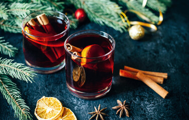 close-up on a hot alcoholic drink mulled wine in two transparent glasses with a cinnamon stick,...