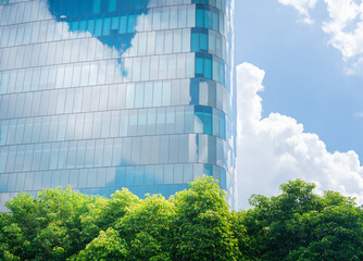 Glass wall architecture friendly building. save energy and fresh green tree reflection cloud and...