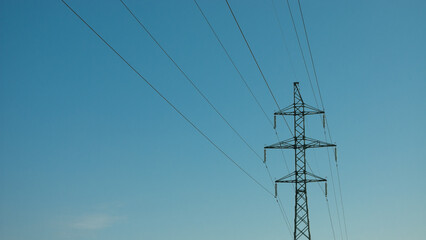 Obraz premium a high-voltage power transmission line, in the photo, a power line support against a blue sky