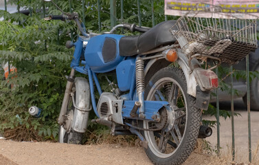 an old abandoned blue motorcycle forgotten by the owner on the street. Old vehicles. Soviet two-wheeled motorcycle.