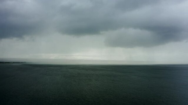 Drone shot on rain clouds over the sea and ocean Black clouds in bad weather over the sea surface. Storm Large stormy dark gloomy rain clouds over a calm sea.