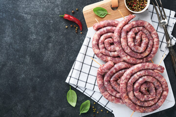 Raw spiral pork sausages. Fresh pork sausages tasty twisted spiral for bbq on white stand with...
