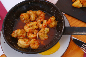 fried shrimps with lemon slice, garlic sauce aioli and tomato ketchup frying pan close up photo