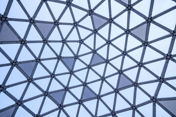 Blue sky background viewed through transparent roof made of the metal and glass pattern 