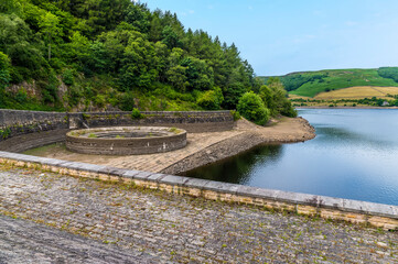 A view from the dam wall towards the overflow plughole on the west shore of Ladybower reservoir, Derbyshire, UK in summertime