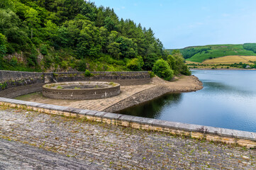 Fototapeta premium A view from the dam wall towards the overflow plughole on the west shore of Ladybower reservoir, Derbyshire, UK in summertime