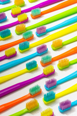 Photo of a modern colorfull toothbrush with differ colors like yellow, violet, blue, green on a white background and marble background flat lay style in studio 