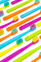 Photo of a modern colorfull toothbrush with differ colors like yellow, violet, blue, green on a white background and marble background flat lay style in studio 