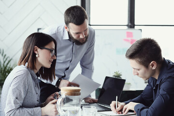 Collaborative Problem-Solving: Two Men and One Woman Engaged in a Productive Business Meeting