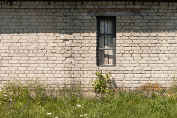 The window of an old brick shed with a wooden frame