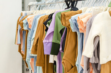 store rack with children's clothes. Floor hanger with clothes for newborns. Clothes Rail with a modern collection of children's cotton clothes for babies. selective focus