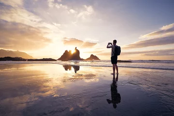 Papier Peint photo autocollant les îles Canaries Homme pendant la photographie de paysage avec falaise. Photographe sur la plage au beau coucher de soleil. Ténérife, Îles Canaries, Espagne..
