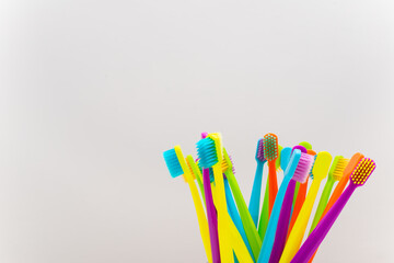 Photo of a modern colorfull toothbrush with differ colors like yellow, violet, blue, green on a white background and marble background flat lay style in studio 