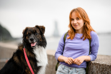 portrait of attractive young smiling woman and shaggy brown dog