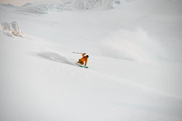 Fototapeta na wymiar extreme freerider skier quickly riding down on snow-covered mountain slope