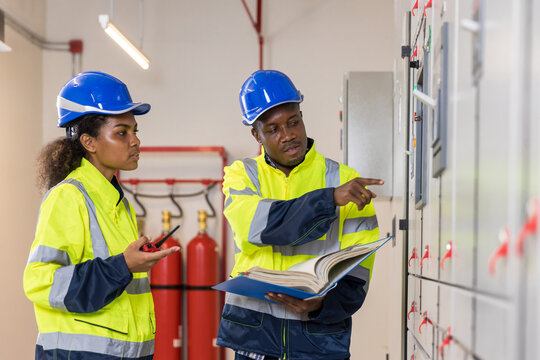 Electrical engineer working in control room. Electrical engineer man checking Power Distribution Cabinet in the control room