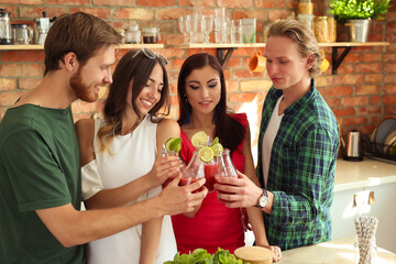 Get the party started with this fun and vibrant stock photo of a group of people enjoying food and drinks in the kitchen.