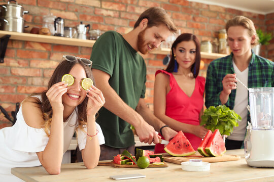 Get the party started with this fun and vibrant stock photo of a group of people enjoying food and drinks in the kitchen.