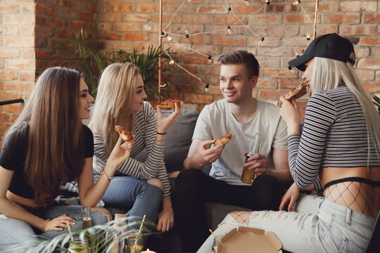 Get the party started with this fun and vibrant stock photo of a group of people enjoying food and drinks in the kitchen