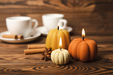 Candles in the form of pumpkins with fragrant coffee on a background of spicy spices of star anise...