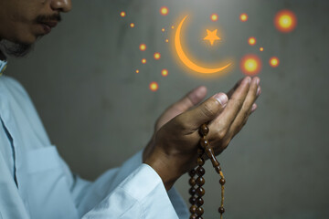 Religious muslim islam man in white session lift two hand for praying to Allah in mosque, isolated on dark background.concept for islamic pray, Ramadan, Eid al Fitr, eid ad-ha, meditation