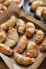 Golden brown croissants, freshly baked and still warm, ready to be enjoyed with a cup of coffee - perfect for a delicious breakfast or snack.