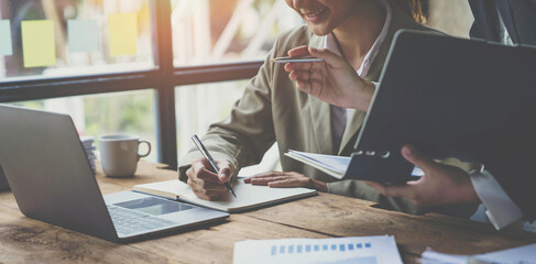 Close up of a group of business people brainstorming describes the list of working together at the office. with new finance project plan during the discussion at the meeting.