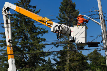 Hydro worker on bucket lift at hydro pole fixing a new residential electric utlility power line