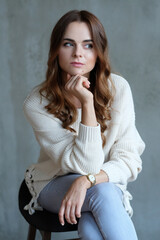 Chic and Confident: Woman Strikes a Pose on a Grey Studio Background, Embodying Modern Style and Elegance