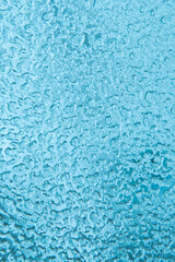 Abstract blue winter background. Texture of frozen water drops, ice surface on the window