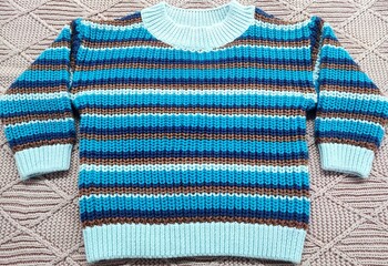 Boys and girls clothes. A beautiful colorful striped little boy sweater or knitted jumper isolated...