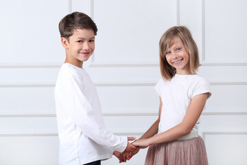 A girl and a boy sit in the studio and pose for a photo