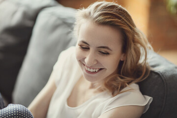 Blonde woman smiling at home taking photo for social media