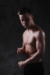 Fototapeta premium Sculpted to Perfection: Male Model Showcases His Fit Physique in a Studio Photoshoot