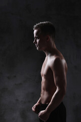 Fototapeta premium Sculpted to Perfection: Male Model Showcases His Fit Physique in a Studio Photoshoot