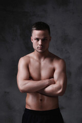 Fototapeta premium Sculpted to Perfection: Male Model Showcases His Fit Physique in a Studio Photoshoot