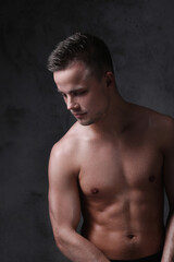 Fototapeta premium Sculpted to Perfection: Male Model Showcases His Fit Physique in a Studio Photoshoot