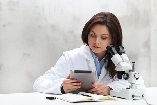 a woman in a lab coat looking through a microscope, portrait of a female pathologist, microscopy, under a microscope, in laboratory, sitting on a lab table, in a laboratory