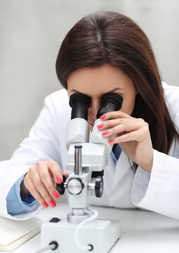 a woman in a lab coat looking through a microscope, portrait of a female pathologist, microscopy, under a microscope, in laboratory, sitting on a lab table, in a laboratory