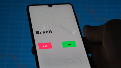 An investor's analyzing the Brazil etf fund on screen. A phone shows the ETF's prices Brazilian...