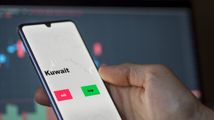 Un investisseur analyse le fonds ETF du Koweït à l'écran. Un téléphone montre les prix des ETF kuwaiti kuwaiti kuwait à investir, texte en anglais.