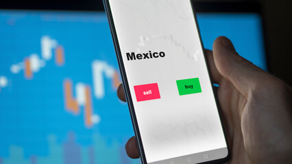 Un investisseur analyse le fonds ETF mexicain à l'écran. Un téléphone affiche les prix de l'ETF Mexicain Mexique à investir, texte en anglais.